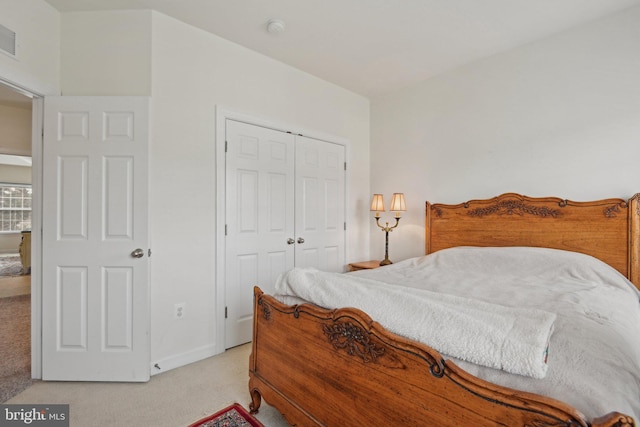 bedroom featuring light carpet, a closet, and baseboards