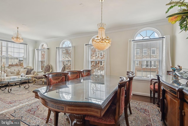 dining room with a chandelier, wood finished floors, and ornamental molding
