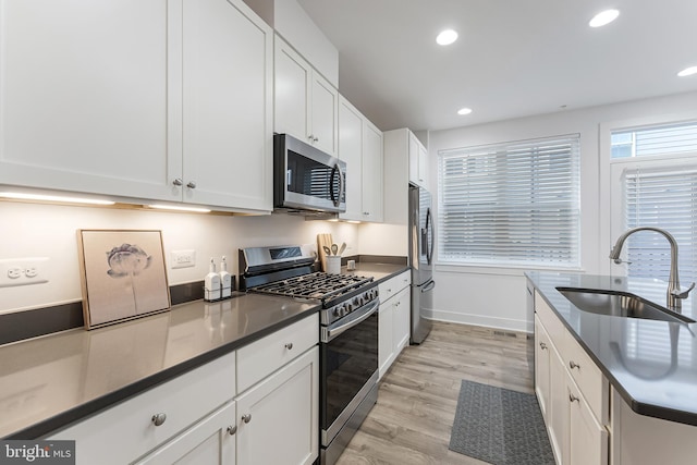 11244 Faraday Park Dr, Reston, VA 20190 - kitchen featuring stainless steel appliances, a sink, light wood-style floors, white cabinets, and recessed lighting