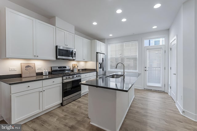 11244 Faraday Park Dr, Reston, VA 20190 - kitchen featuring stainless steel appliances, a sink, light wood finished floors, dark countertops, and recessed lighting