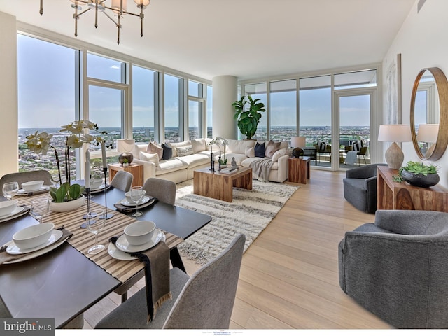 living area featuring expansive windows, light wood-type flooring, and a chandelier
