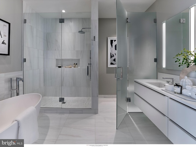 full bath with a stall shower, vanity, and a freestanding tub