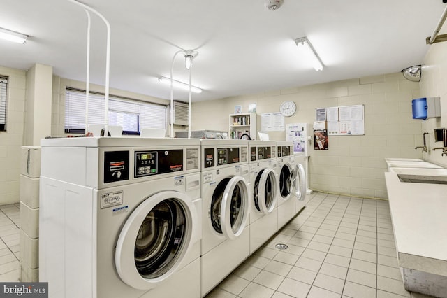 1601 18th St NW Unit 1015, Washington, DC 20009 - community laundry with independent washer and dryer, light tile patterned flooring, and concrete block wall