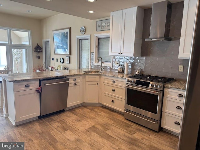 18 Ebb Tide Ct, Ocean Pines, MD 21811 - kitchen with appliances with stainless steel finishes, wall chimney range hood, a peninsula, a sink, and backsplash