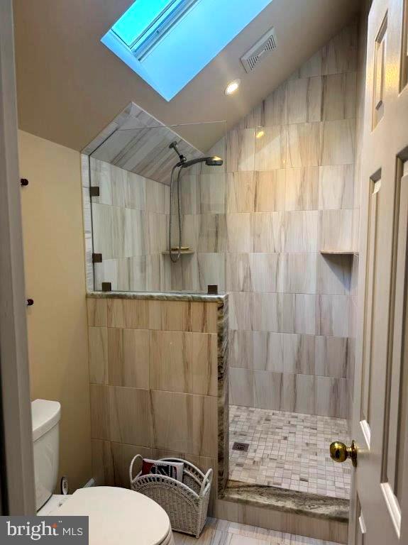 18 Ebb Tide Ct, Ocean Pines, MD 21811 - full bath with toilet, tiled shower, tile walls, and vaulted ceiling