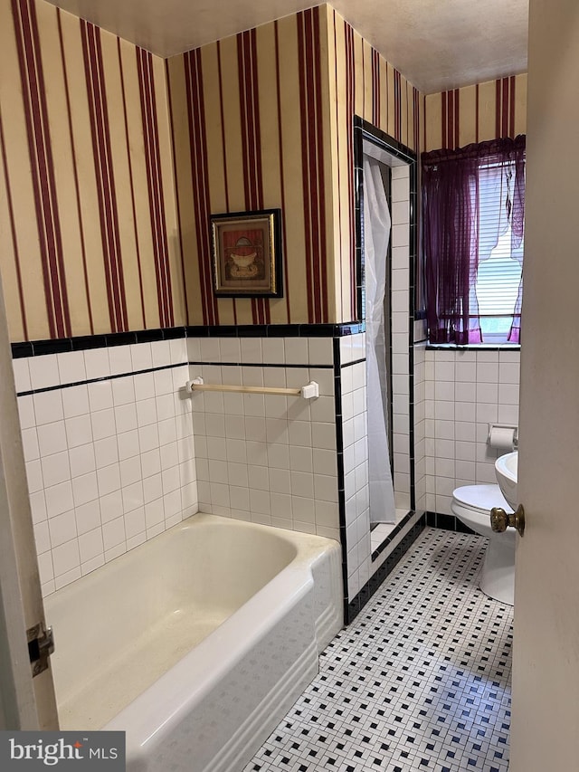 full bath featuring tile walls, toilet, wallpapered walls, tile patterned floors, and a bathtub