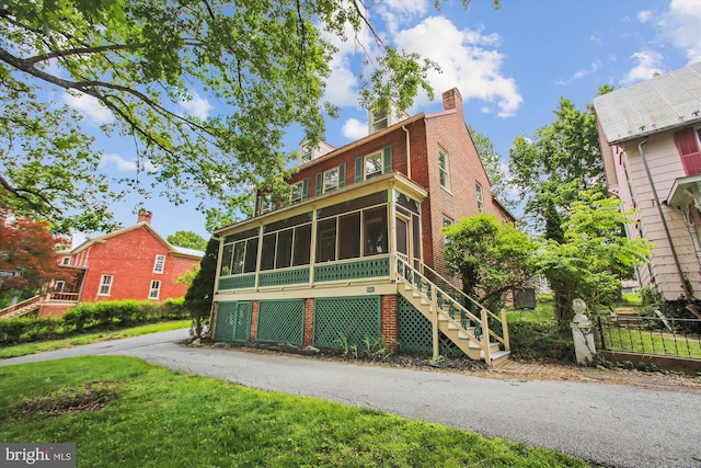 501 Park Row Pl, Harpers Ferry, WV 25425 - view of front of home featuring a sunroom, a chimney, stairway, brick siding, and a front yard