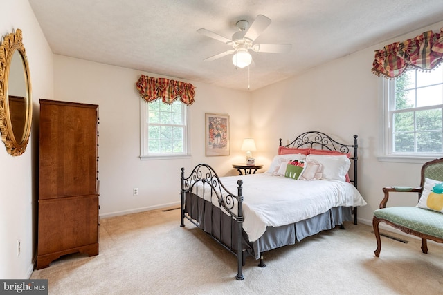 carpeted bedroom with baseboards and a ceiling fan
