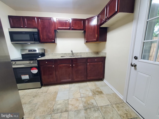 117 S Shenandoah Ave, Front Royal, VA 22630 - kitchen with appliances with stainless steel finishes, reddish brown cabinets, a sink, and light stone counters