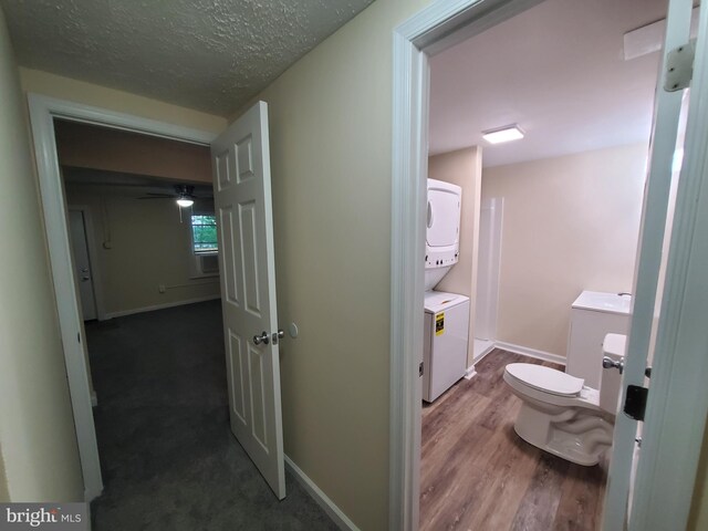 117 S Shenandoah Ave, Front Royal, VA 22630 - hall featuring stacked washer / drying machine, dark wood-style flooring, baseboards, and a textured ceiling