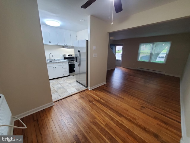 117 S Shenandoah Ave, Front Royal, VA 22630 - kitchen featuring appliances with stainless steel finishes, a baseboard radiator, a sink, light wood-style flooring, and white cabinets