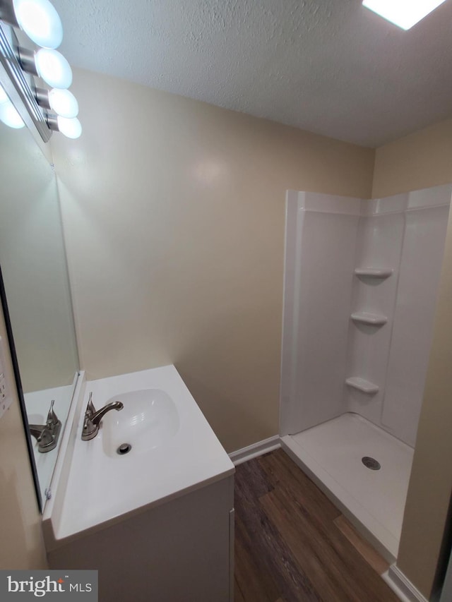 117 S Shenandoah Ave, Front Royal, VA 22630 - full bathroom with vanity, wood finished floors, a shower, a textured ceiling, and baseboards