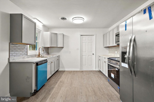 104 Louise Ave, Salisbury, MD 21804 - kitchen featuring stainless steel appliances, a sink, tasteful backsplash, light wood-style flooring, and light countertops