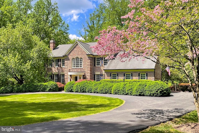 7808 Devereux Manor Ct, Fairfax Station, VA 22039 - colonial house with brick siding, a chimney, and a front yard