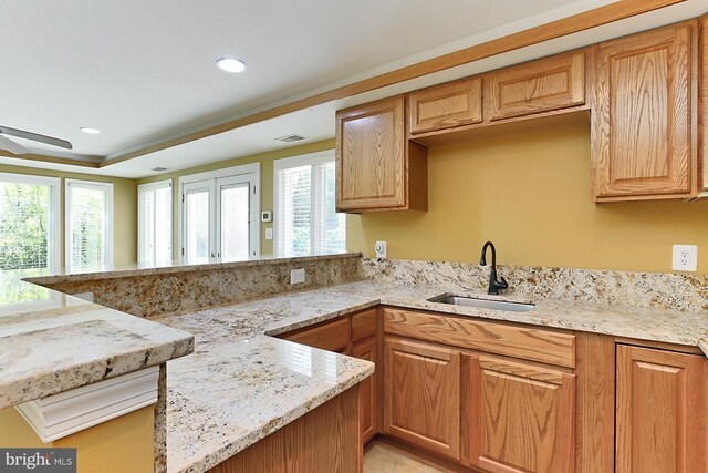 7808 Devereux Manor Ct, Fairfax Station, VA 22039 - kitchen featuring a sink, a peninsula, plenty of natural light, light stone countertops, and recessed lighting