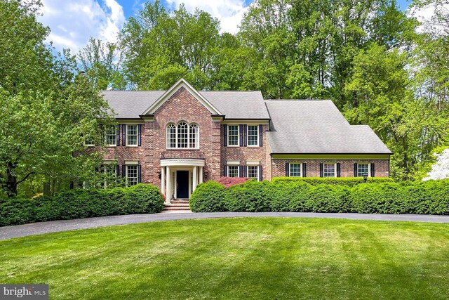 7808 Devereux Manor Ct, Fairfax Station, VA 22039 - colonial house with brick siding, a front yard, and a shingled roof