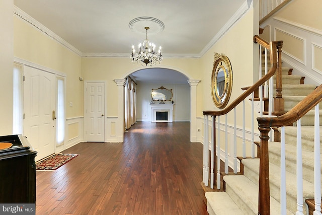 7808 Devereux Manor Ct, Fairfax Station, VA 22039 - entrance foyer featuring arched walkways, a chandelier, a fireplace, wood-type flooring, and a decorative wall