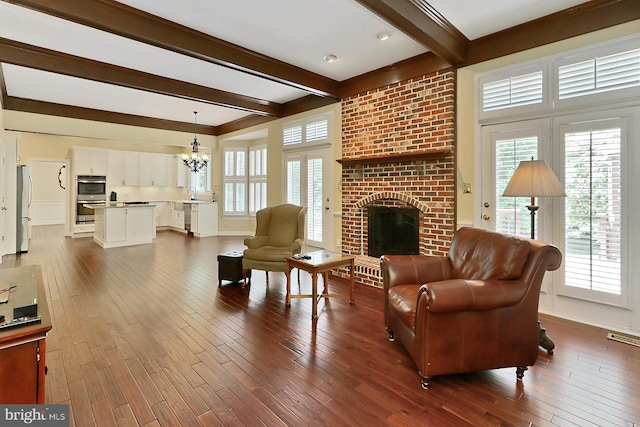 7808 Devereux Manor Ct, Fairfax Station, VA 22039 - living area with beamed ceiling, a chandelier, dark wood-type flooring, and a brick fireplace