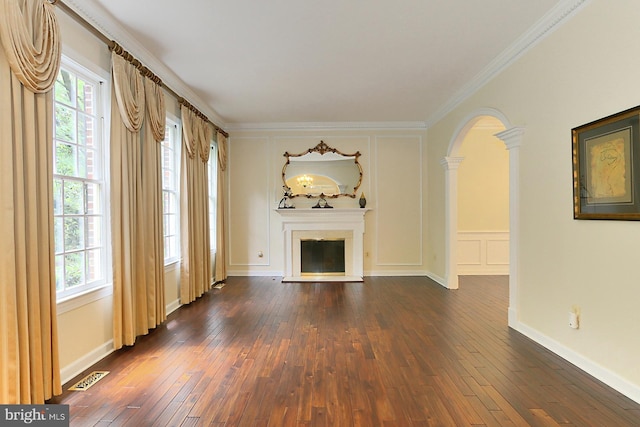 7808 Devereux Manor Ct, Fairfax Station, VA 22039 - unfurnished living room featuring a decorative wall, dark wood-style floors, a fireplace with raised hearth, arched walkways, and crown molding