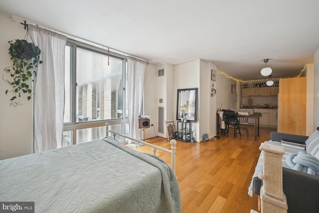 bedroom with multiple windows and wood finished floors