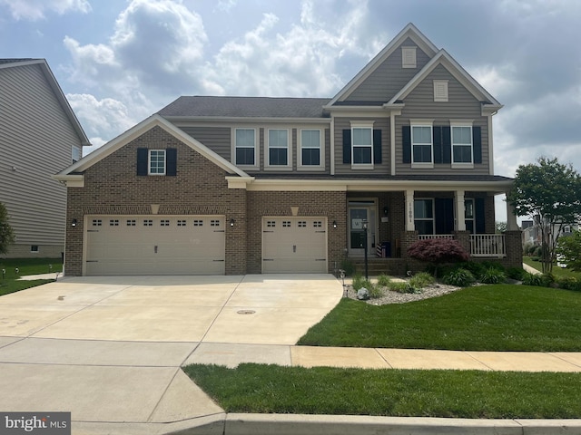 craftsman-style home featuring brick siding, driveway, an attached garage, a front lawn, and a porch