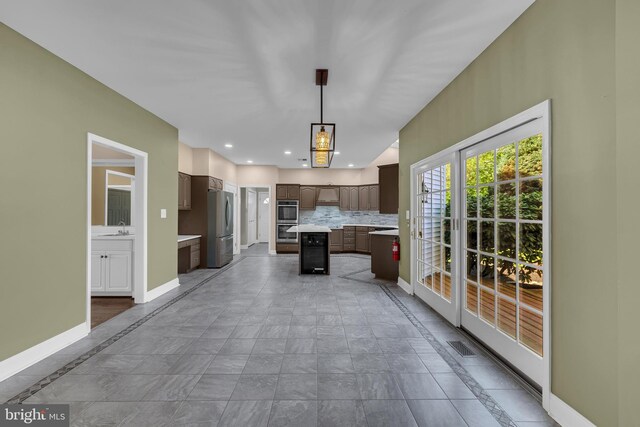 4 Stults Dr, Plainsboro, NJ 08536 - kitchen featuring appliances with stainless steel finishes, a center island, baseboards, light countertops, and dark brown cabinets