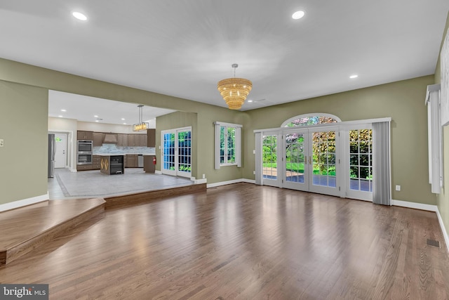 4 Stults Dr, Plainsboro, NJ 08536 - unfurnished living room with baseboards, recessed lighting, light wood-style flooring, and a chandelier