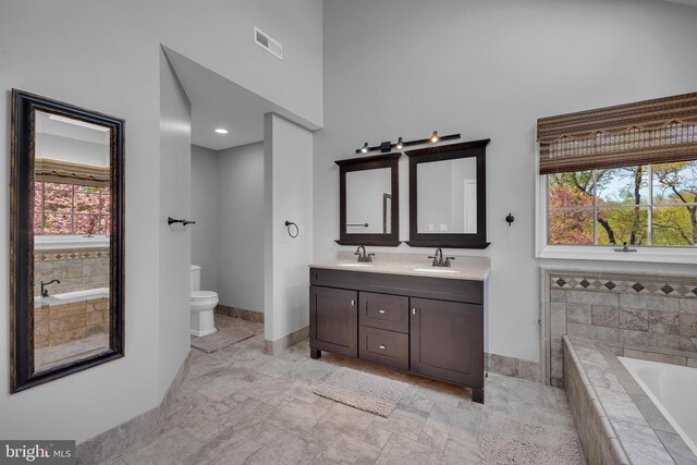 4 Stults Dr, Plainsboro, NJ 08536 - bathroom featuring a garden tub, double vanity, a high ceiling, toilet, and baseboards