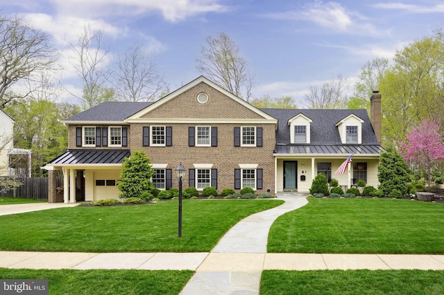 902 Emerald Dr, Alexandria, VA 22308 - view of front facade with a standing seam roof, a chimney, brick siding, and metal roof