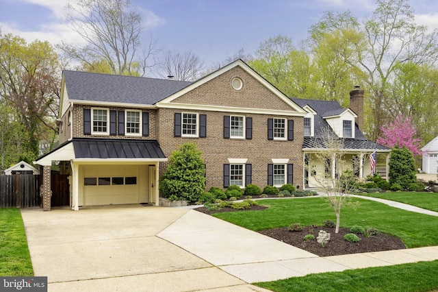902 Emerald Dr, Alexandria, VA 22308 - view of front facade with brick siding, an attached garage, concrete driveway, a shingled roof, and a standing seam roof