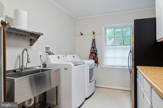 902 Emerald Dr, Alexandria, VA 22308 - clothes washing area featuring washer and dryer, crown molding, baseboards, cabinet space, and light flooring