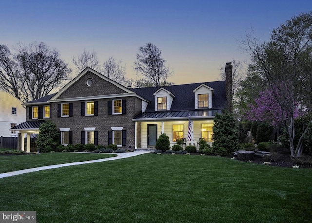902 Emerald Dr, Alexandria, VA 22308 - view of front of home featuring a standing seam roof, a front lawn, covered porch, a chimney, and metal roof
