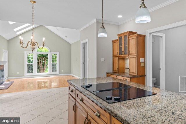 502 Pride Of Baltimore Dr, Arnold, MD 21012 - kitchen featuring black electric cooktop, a skylight, hanging light fixtures, light stone countertops, and ornamental molding
