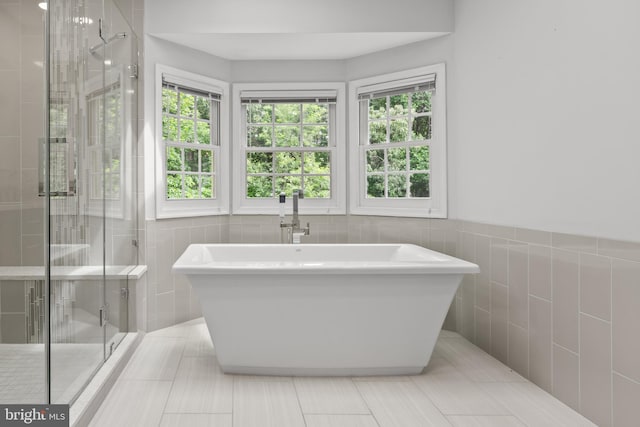 502 Pride Of Baltimore Dr, Arnold, MD 21012 - bathroom featuring tile walls, a freestanding tub, a stall shower, and plenty of natural light