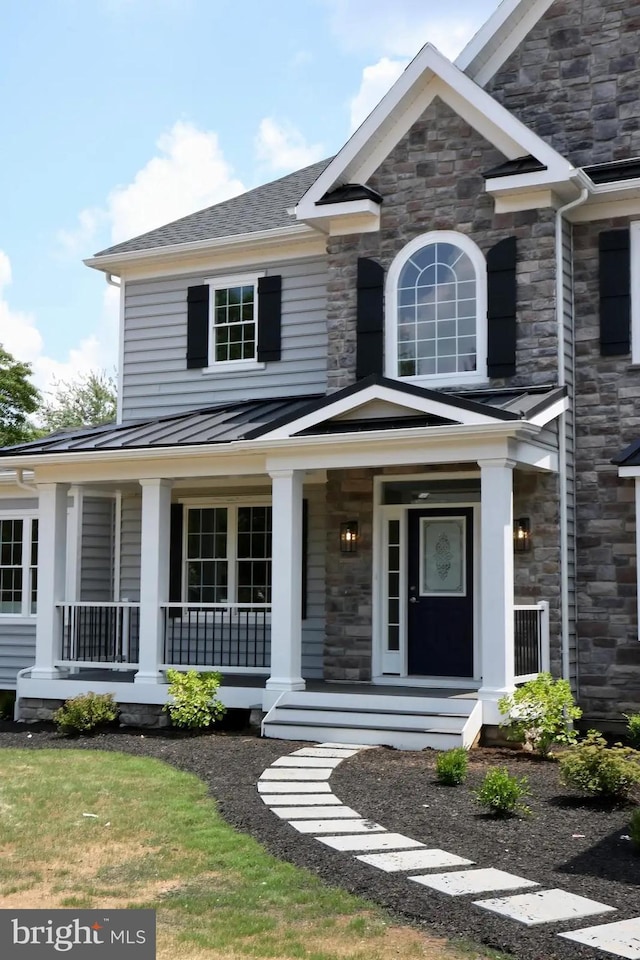 64B Kirk Rd, Garnet Valley, PA 19061 - view of front facade featuring covered porch, stone siding, a standing seam roof, and metal roof