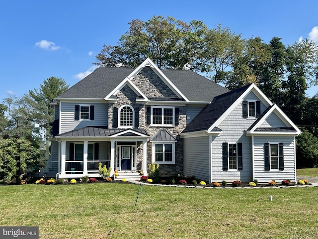 64B Kirk Rd, Garnet Valley, PA 19061 - view of front of house with covered porch, a standing seam roof, a front yard, and stone siding