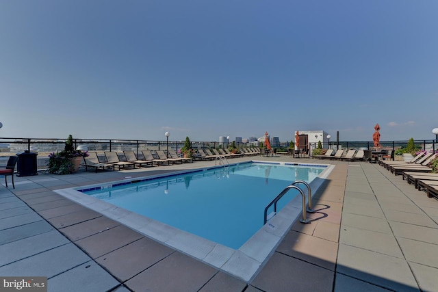 community pool featuring fence and a patio