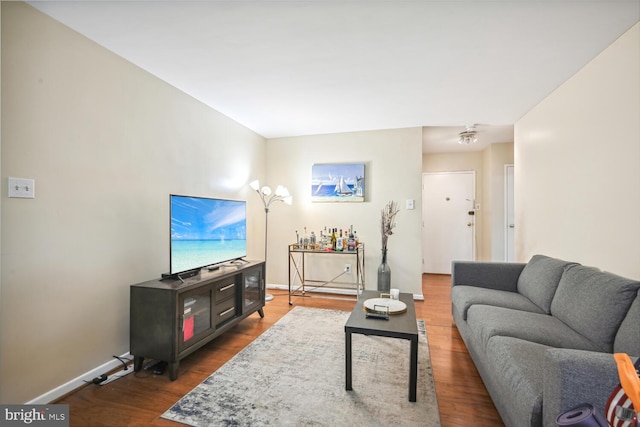 living room with baseboards and dark wood finished floors