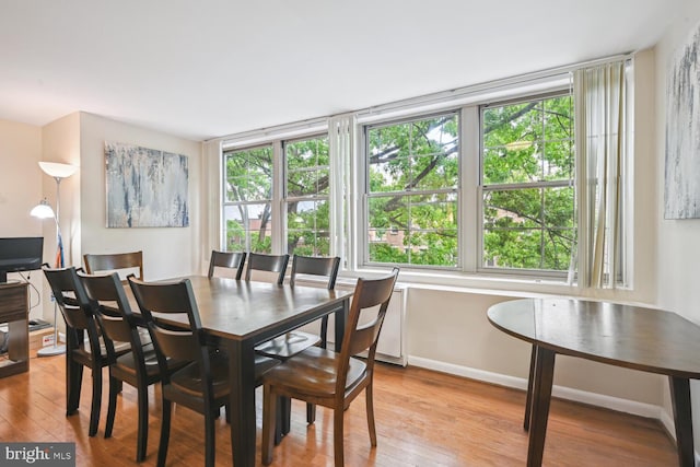 dining area with light wood-style flooring and baseboards