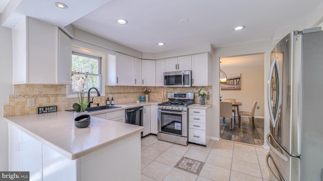 6057 English Creek Ave, Egg Harbor Township, NJ 08234 - kitchen with stainless steel appliances, a sink, light countertops, white cabinetry, and tasteful backsplash