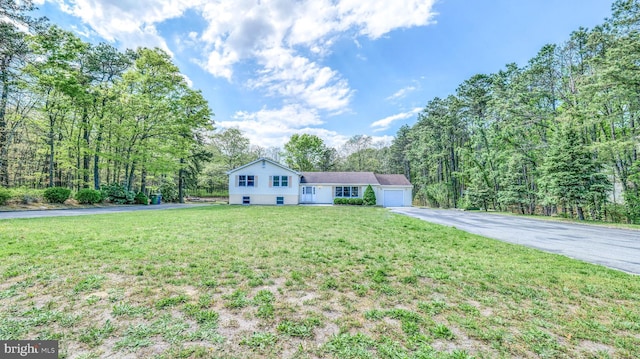 6057 English Creek Ave, Egg Harbor Township, NJ 08234 - tri-level home with asphalt driveway, an attached garage, a front lawn, and a view of trees