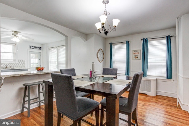4527 Devereaux St, Philadelphia, PA 19135 - dining area with arched walkways, a chandelier, light wood-type flooring, ceiling fan, and baseboards