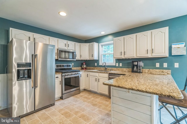 134 Whitaker Ave, North East, MD 21901 - kitchen featuring stainless steel appliances, a peninsula, a sink, light stone countertops, and recessed lighting