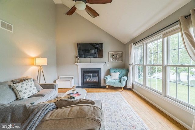 134 Whitaker Ave, North East, MD 21901 - living room with healthy amount of natural light, lofted ceiling, a glass covered fireplace, wood finished floors, and a ceiling fan