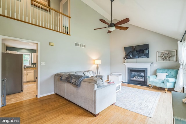 134 Whitaker Ave, North East, MD 21901 - living room featuring high vaulted ceiling, a ceiling fan, light wood-style flooring, a glass covered fireplace, and beam ceiling