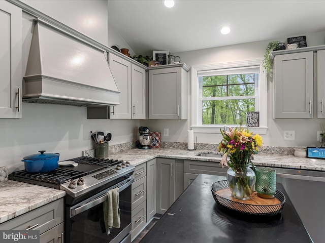 kitchen featuring gas range, custom exhaust hood, gray cabinetry, recessed lighting, and light stone countertops