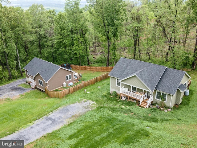 aerial view of property and surrounding area featuring a heavily wooded area