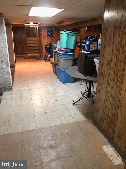 3812 Gwynn Oak Ave, Baltimore, MD 21207 - finished below grade area with wooden walls, tile patterned floors, stairs, and a drop ceiling