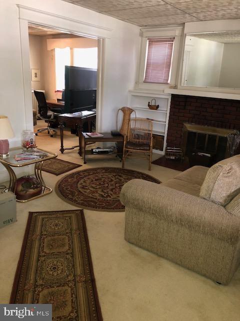 3812 Gwynn Oak Ave, Baltimore, MD 21207 - living room featuring carpet and a fireplace