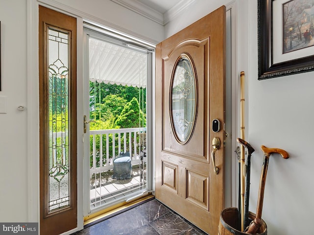 entrance foyer featuring dark marble finish floors and crown molding